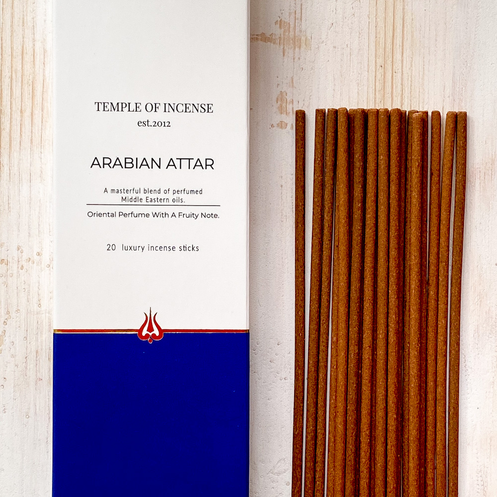 Incense sticks with packaging labeled 'Temple of Incense Arabian Attar' on a light wooden background
